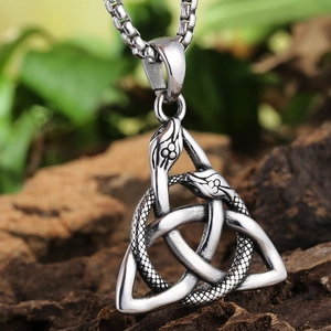 Macro view of Celtic knot double snake pendant with vintage silver finish on bark