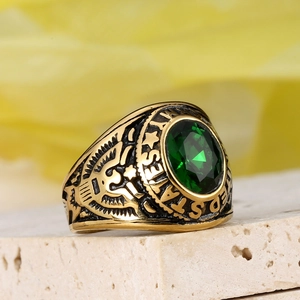 Detail of vintage gold-plated army ring with oval green gemstone and eagle relief