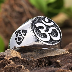 Vintage stainless steel Om ring for men with engraved religious symbol on a wood block