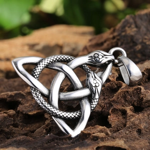 Detailed close-up of a Celtic knot twin snake pendant on rustic dark tree bark background