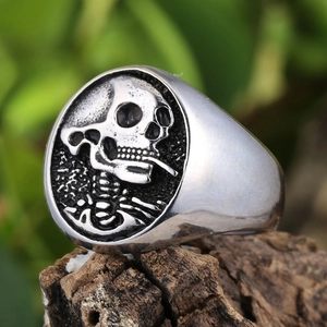 Vue macro d'une bague chevalière tête de mort en acier 304 sur un support en bois