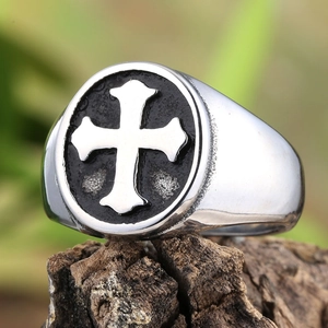 Macro detail of a vintage stainless steel cross ring for men with embossed texture