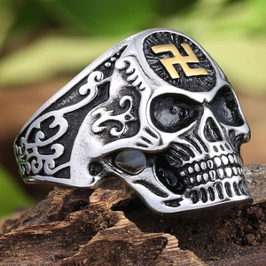 Macro shot of punk skull ring with gold swastika and intricate vintage relief carving