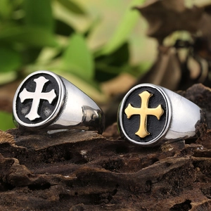 Detail of vintage cross emblem rings in silver and gold on rustic wood surface