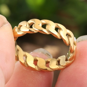 Bague chaîne cubaine dorée avec texture tissée continue portée sur une main humaine