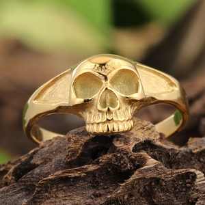 Bague tête de mort gothique rétro au fini doré poli sur fond de bois rustique