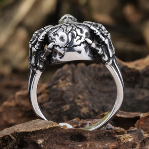 Macro shot of vintage silver skeleton hand ring with gothic bone details on wood