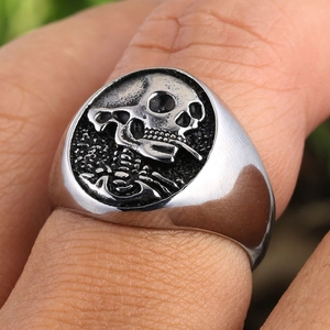 Macro d'une bague tête de mort qui fume en argent montrant les détails punk du métal