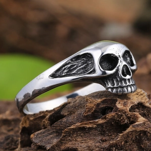 Vue macro d'une bague tête de mort vintage en argent sur écorce avec détails gothiques
