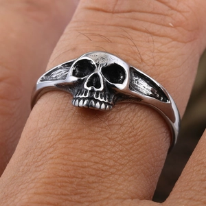 Détail macro d'une bague tête de mort gothique en acier argenté vintage avec gravures