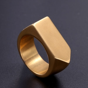 Macro side view of matte gold irregular hexagonal ring with brushed metal texture