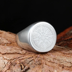 Vintage stainless steel compass ring for men with starburst design on wooden texture