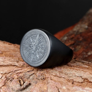 Vintage matte black stainless steel compass signet ring for men on rustic bark background