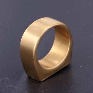 Detailed close-up of a matte gold stainless steel ring with an irregular flat-bottom design