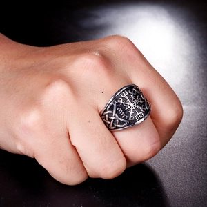 Detail of vintage silver Viking compass ring with runes and Vegvisir symbol on finger