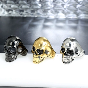 Detailed view of punk skull rings in polished silver, gold, and matte black finishes