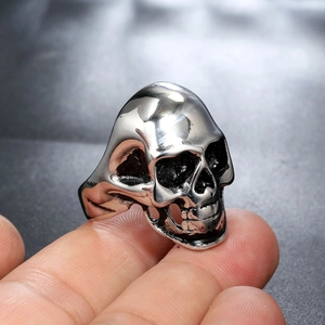Close-up of a silver skull ring in stainless steel with detailed oxidized finish on finger