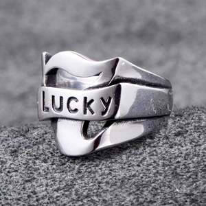 Vintage stainless steel ring with hollow wave design and LUCKY engraving on grey background
