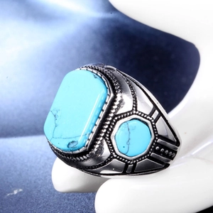 Macro view of vintage style men's ring with turquoise stones on polished metal band