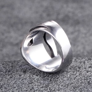 Detailed 45-degree macro view of silver polished stainless steel wide band ring