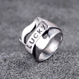 Minimalist silver stainless steel wide wave ring with engraved LUCKY text on a textured surface