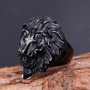 Macro shot of 3D lion head ring in matte black steel on natural wood texture