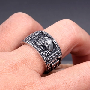 Vue macro d'une bague tête de mort punk rétro avec reliefs de croix et fini argenté