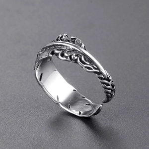 Macro view of vintage feather ring showing detailed texture and oxidized steel finish
