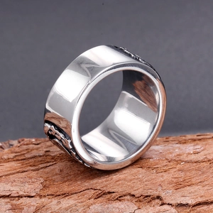 Gros plan sur bague en acier inoxydable poli avec gravures rétro sur bois