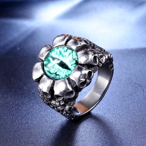 Macro view of gothic skull ring band with a vibrant green evil eye center stone