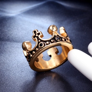 Vue macro d'une bague couronne en acier doré vintage avec croix et cristaux noirs