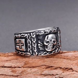 Bague gothique en acier inoxydable avec crâne et croix sur un support en écorce