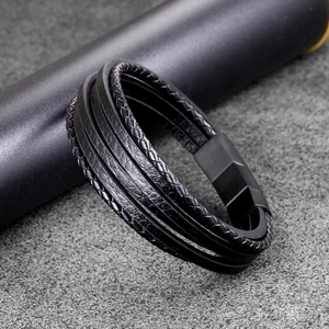 Detail of multi-layer black braided leather bracelet with matte metal magnetic clasp