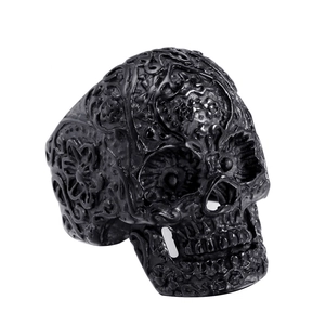 Macro shot of black gothic skull ring featuring intricate floral and vine relief carvings