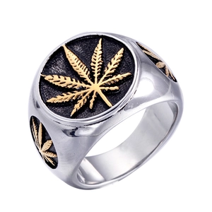 Macro view of stainless steel ring with golden cannabis leaf relief and black texture