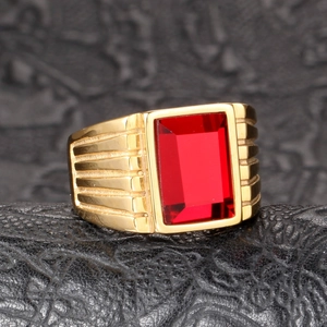 Macro detail of men's gold ring with a large red rectangular stone and ribbed band