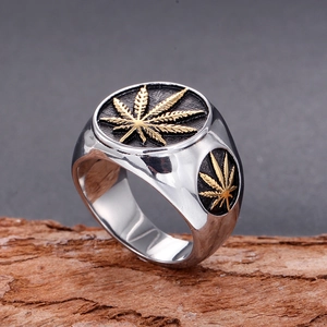 Detailed macro shot of men's stainless steel signet ring with golden maple leaf motifs