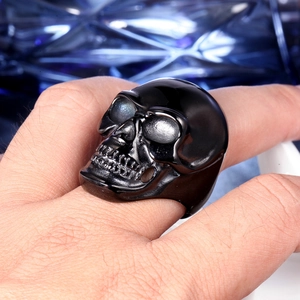 Macro shot of a gothic black skull ring in polished stainless steel on a finger