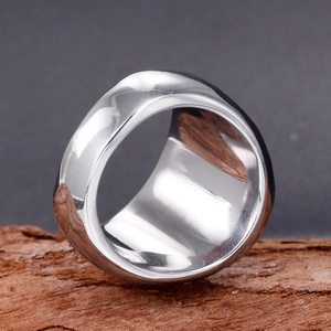 Macro shot of polished stainless steel wide ring with asymmetric minimalist geometric design