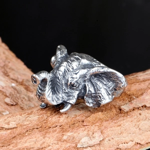 Detailed close-up of a silver punk elephant head ring with vintage textured finish on wood