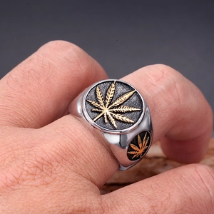 Macro shot of silver signet ring with gold leaf relief and black enamel on male finger