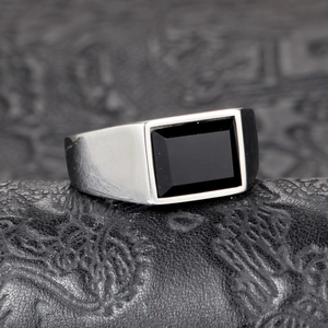 Macro detail of men's titanium steel signet ring featuring a polished rectangular black onyx inlay