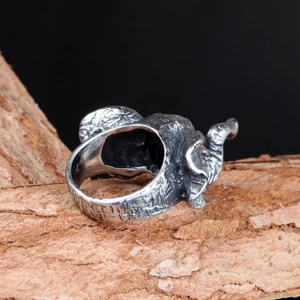 Detailed close-up of a vintage silver elephant ring with textured skin on wood bark