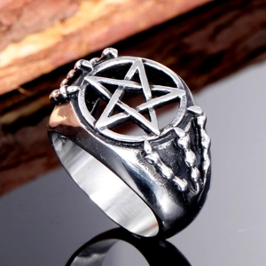 Vintage stainless steel pentagram ring with chain texture detail on a black surface