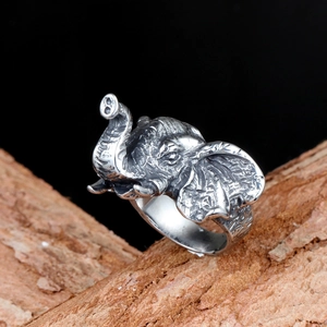 Macro shot of retro silver elephant ring with detailed carvings on natural wood