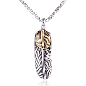 Macro shot of two-tone vintage feather pendant with detailed engraving on box chain