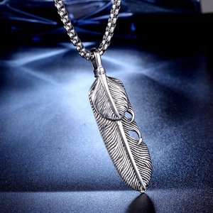 Macro detail of vintage silver double feather pendant with textured oxidation finish