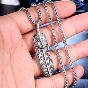 Detail of vintage silver double feather pendant necklace with round box chain