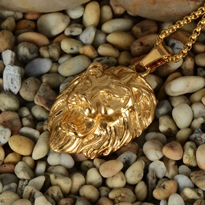 Detailed close-up of golden lion head pendant with intricate mane texture on grey stones