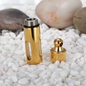 Golden bullet perfume bottle pendant with glass window on white pebbles
